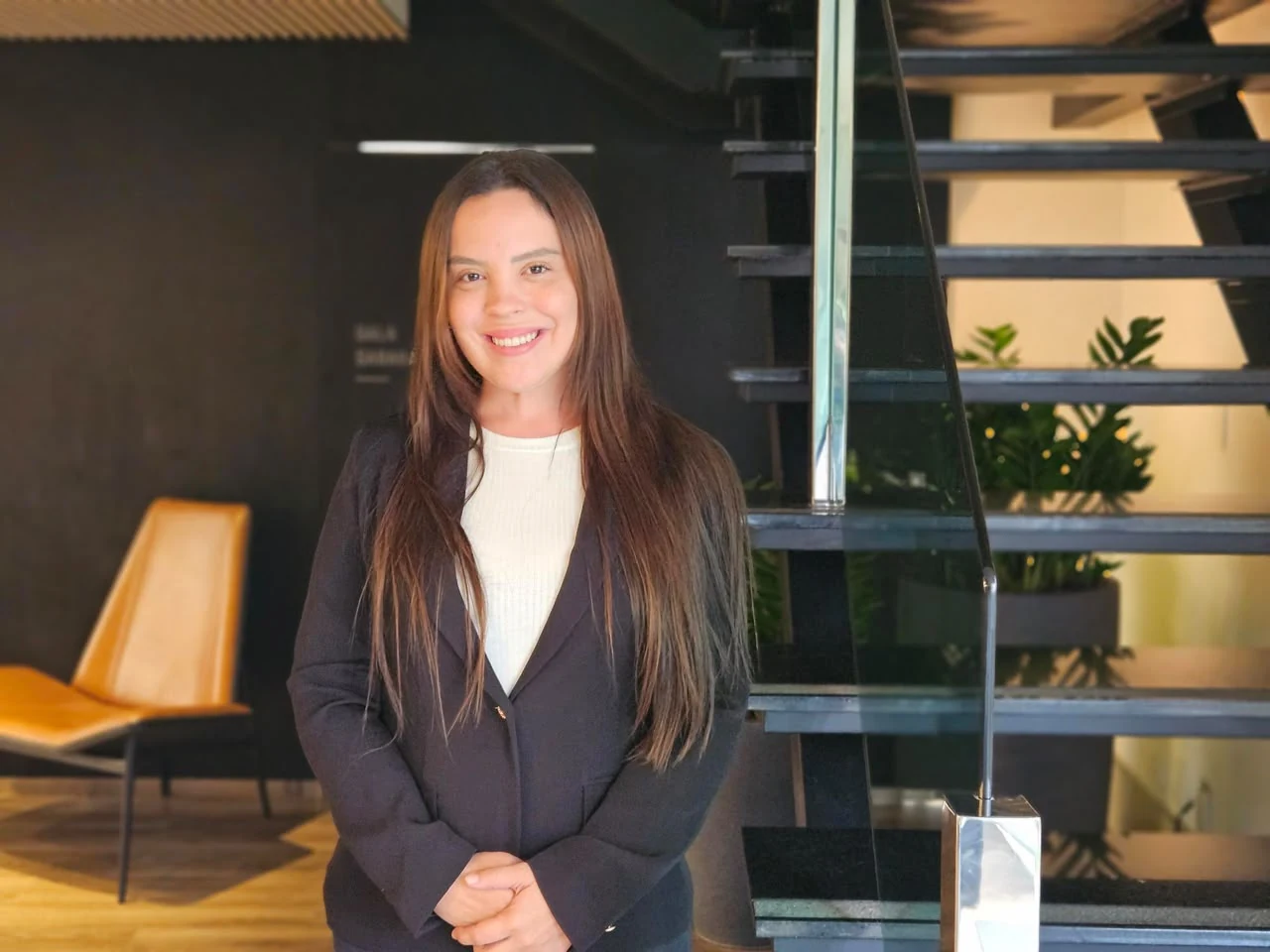 Dra. Fernanda Moura em ambiente profissional junto a uma escada